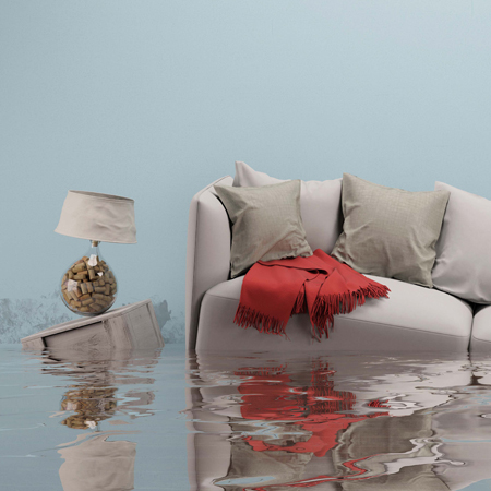 Dégâts des eaux après une inondation dans une maison avec un canapé dans le salon